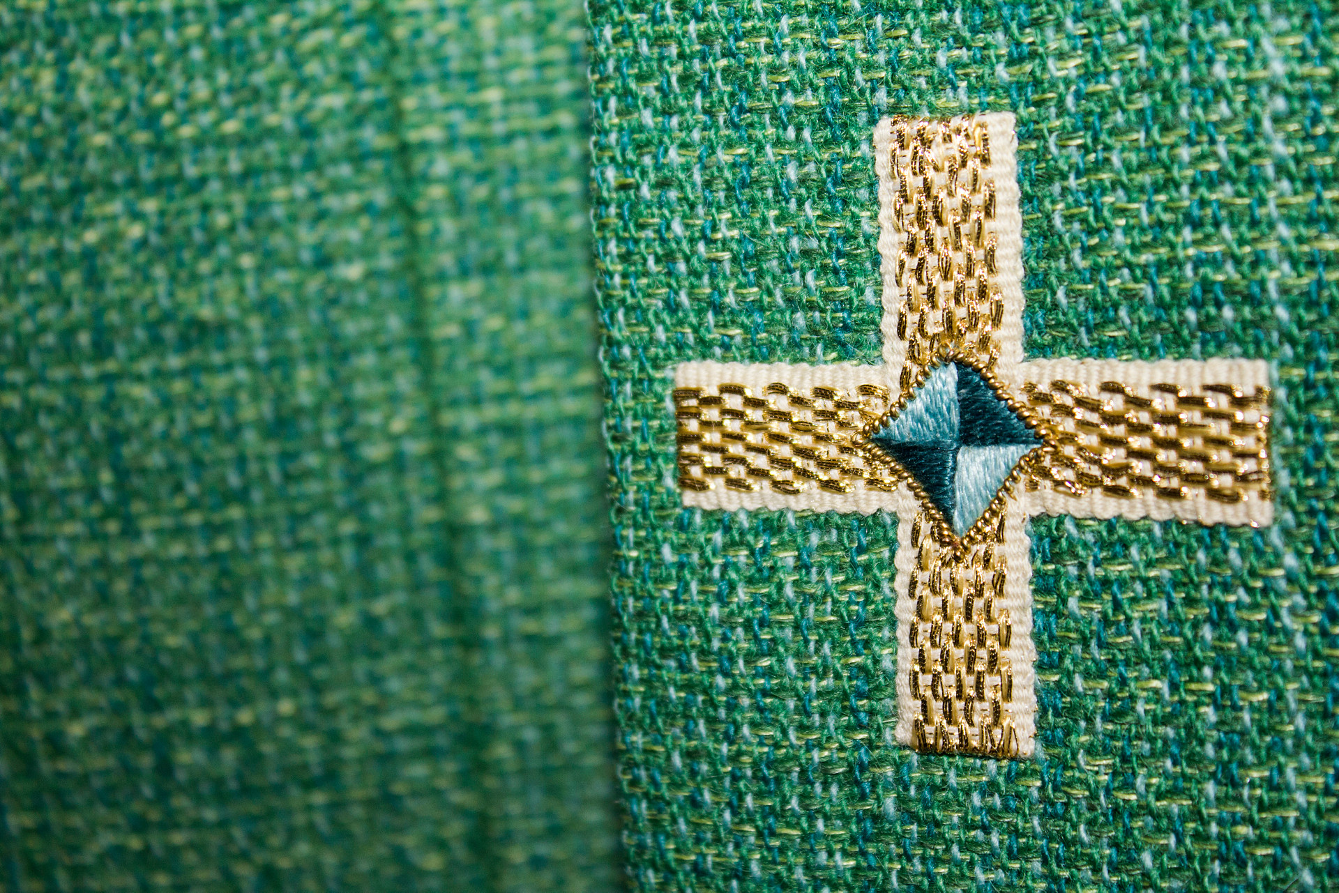 Närbild av kors på grönt tyg.