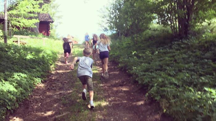 Barn som springer längs en väg i skogen