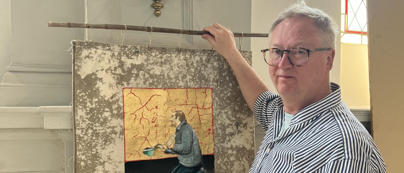 Konstnären och prästen Mats Hermansson hänger upp en presenningsikon i Stora Hammars kyrka.