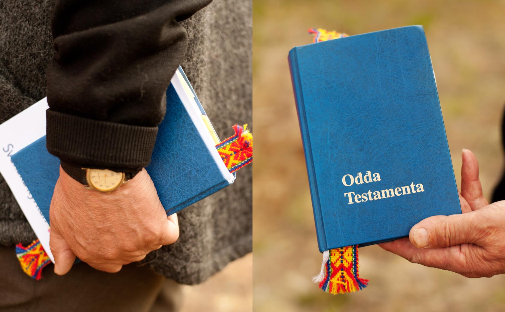 En person går och bär på en samisk utgåva av gamla testamentet.