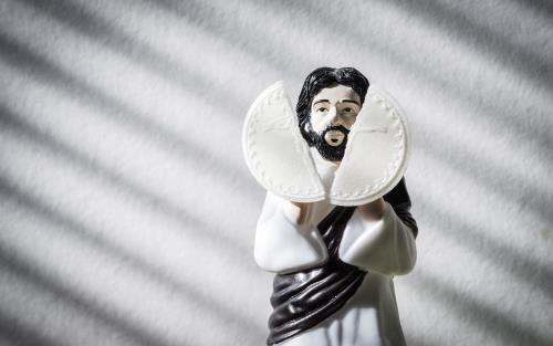 En liten figur av Jesus som bryter en oblat.