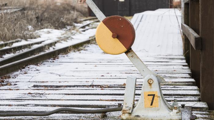 En gammal järnvägsväxel bredvid en snöig tågräls.