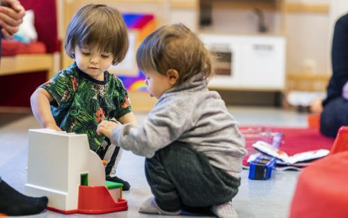 Två barn samspelar vid en leksaks-kassaapparat.