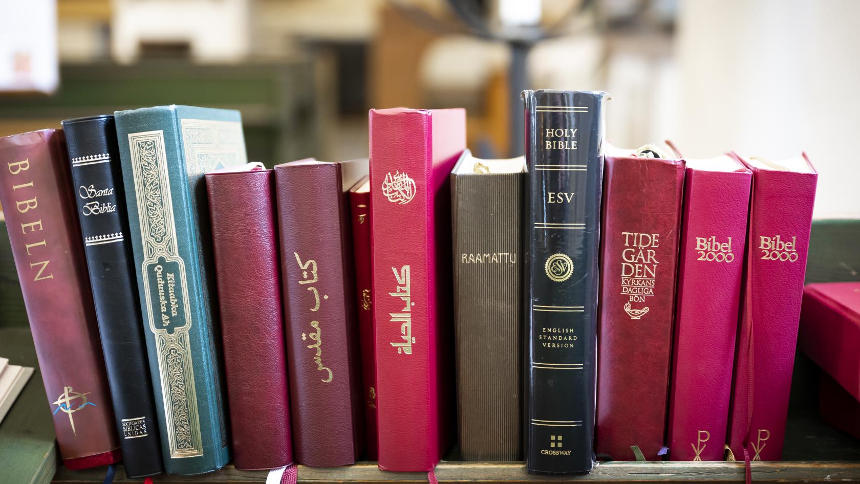 Biblar på olika språk står i en bokhylla i kyrkan.