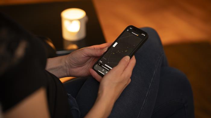 En person sitter och tittar på Svenska kyrkans bönewebb på sin smartphone.
Foc
