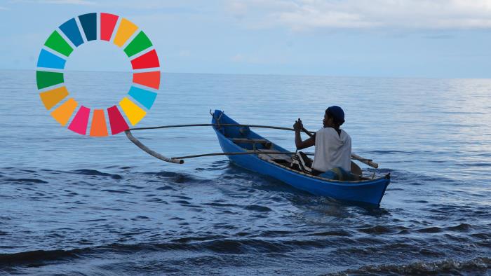 Fiskare från Indonesien, ensam i blå båt ute på havet. Till vänster syns loggan för Agenda 2030.
