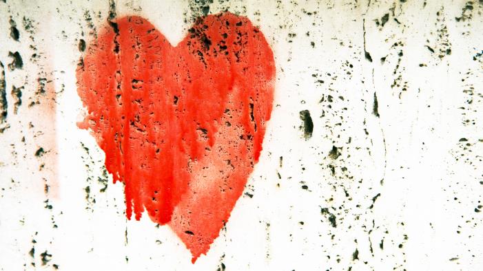 Ett målat rött hjärta på en vit vägg.