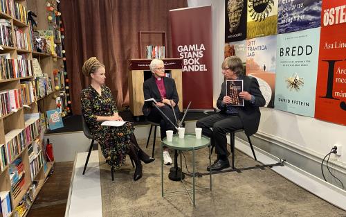 Vid ett bord i Gamla stans bokhandel sitter Kulturminister Amanda Lind och ärkebiskop Antje Jackelén.