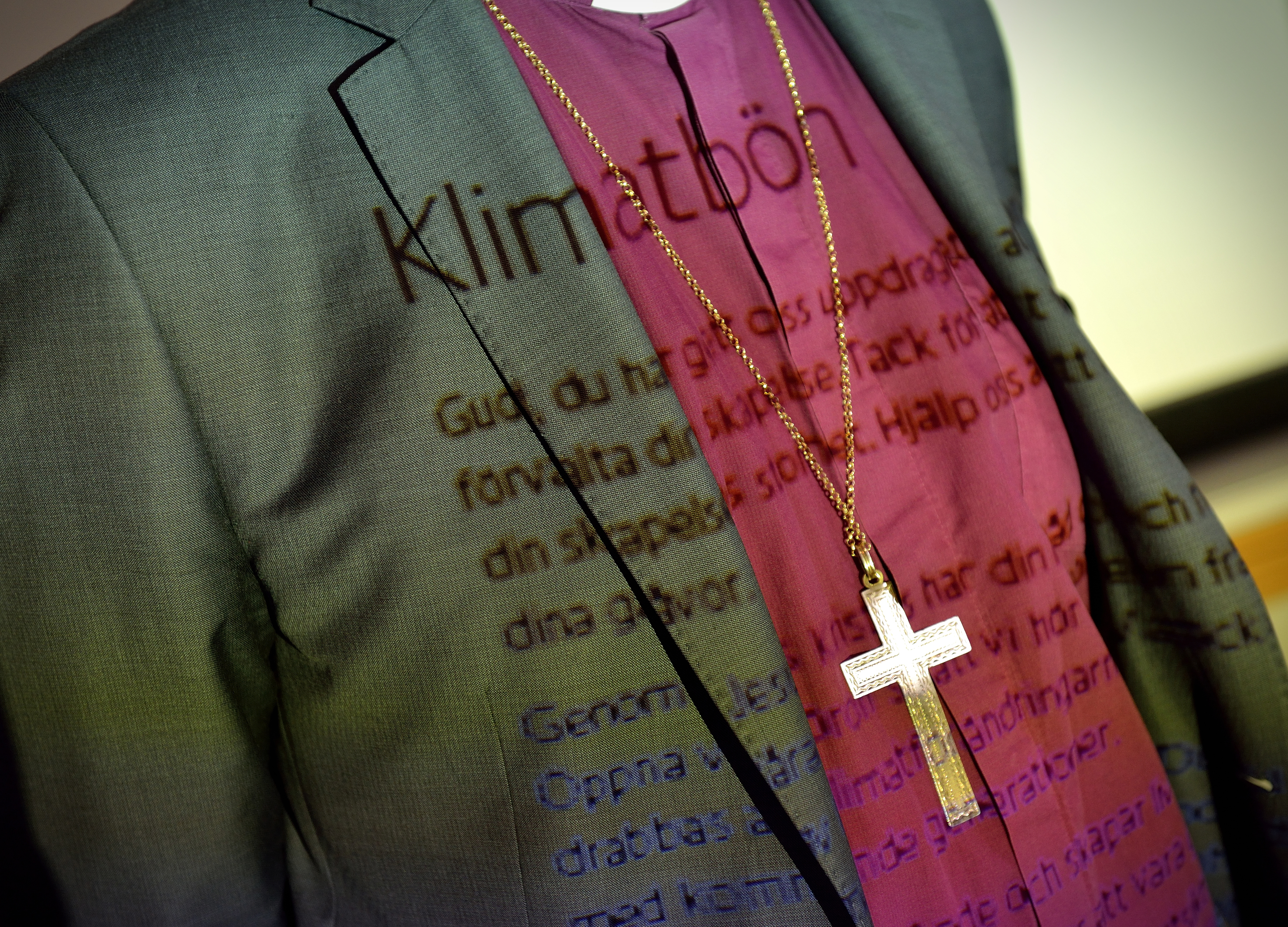 Texten till en klimatbön projicerad på en biskops kläder.