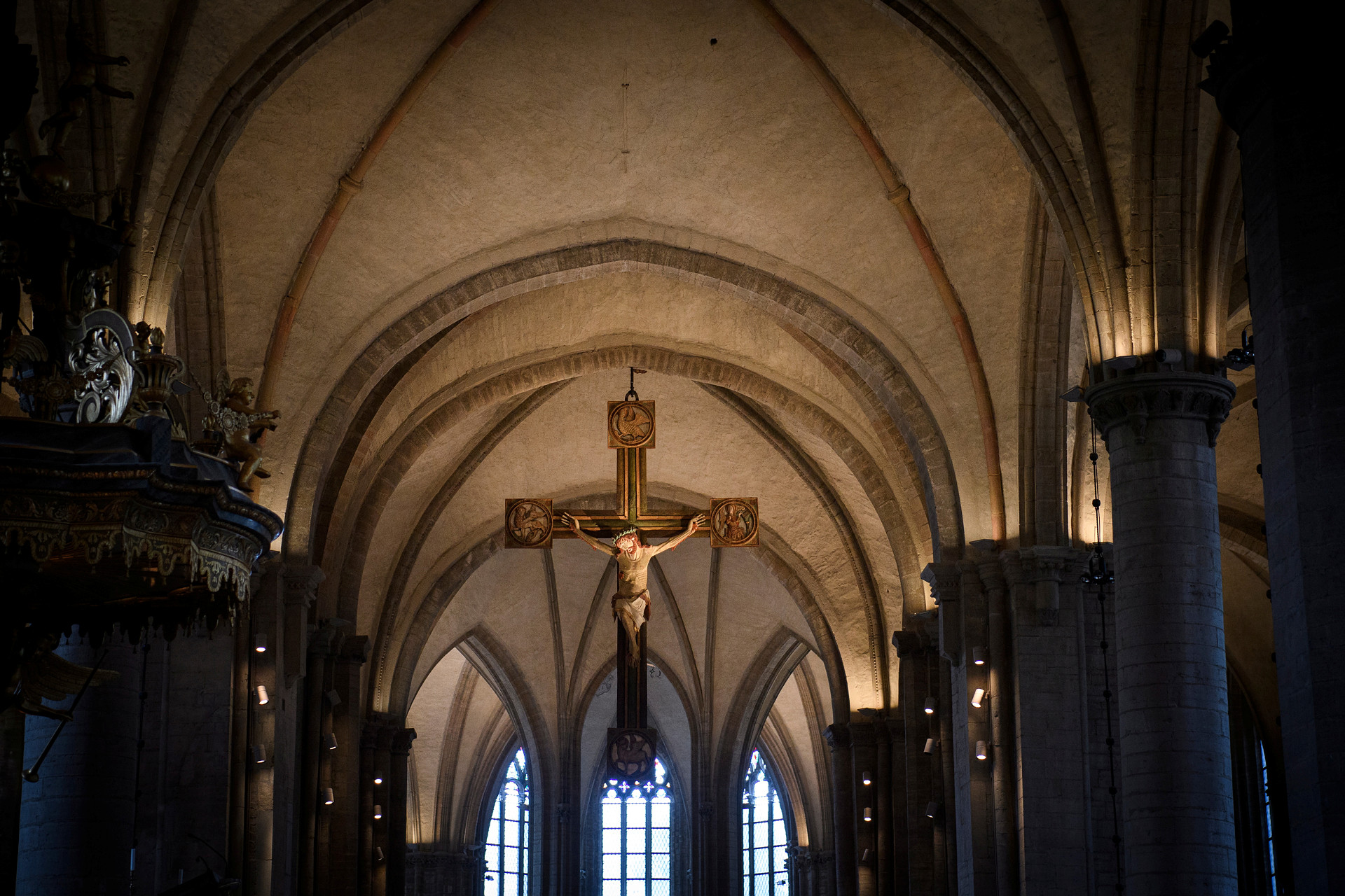 Kyrkorum med upplysta valv, i centrum av bilden ett triumfkrucifix.