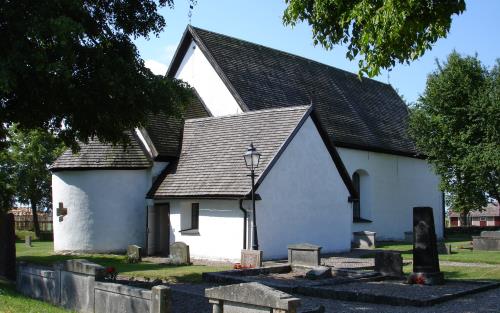 Kumla kyrka. En liten vitrappad stenkyrka med spåntak.