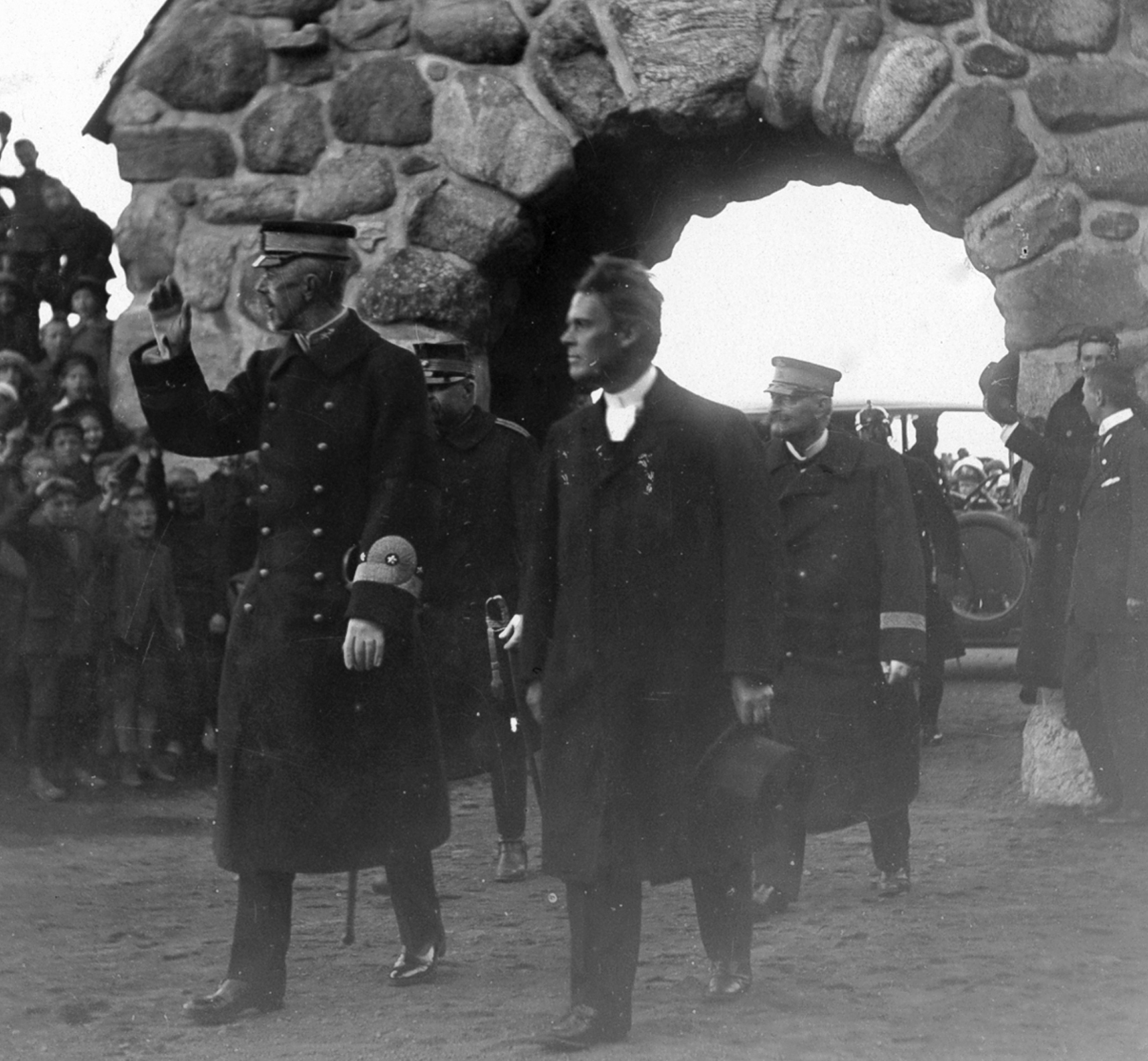 Kung Gustav V och hans följe går in på gården framför huvudingången till Masthuggskyrkan. 