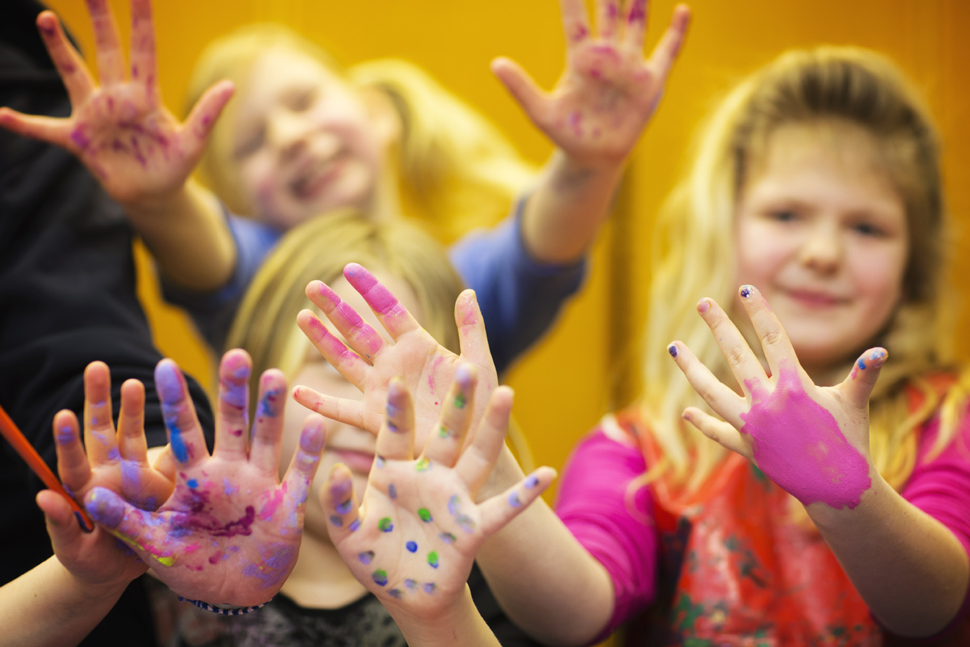 Glada barn med färger på fingrarna.