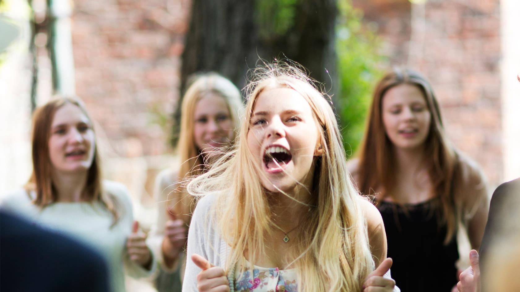 Glada ungdomar utanför kyrka, sommarbild