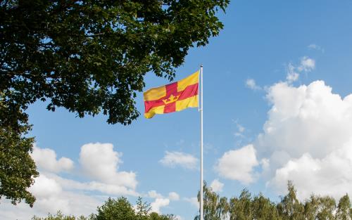 Svenska kyrkans röda och gula flagga vajar i vinden.