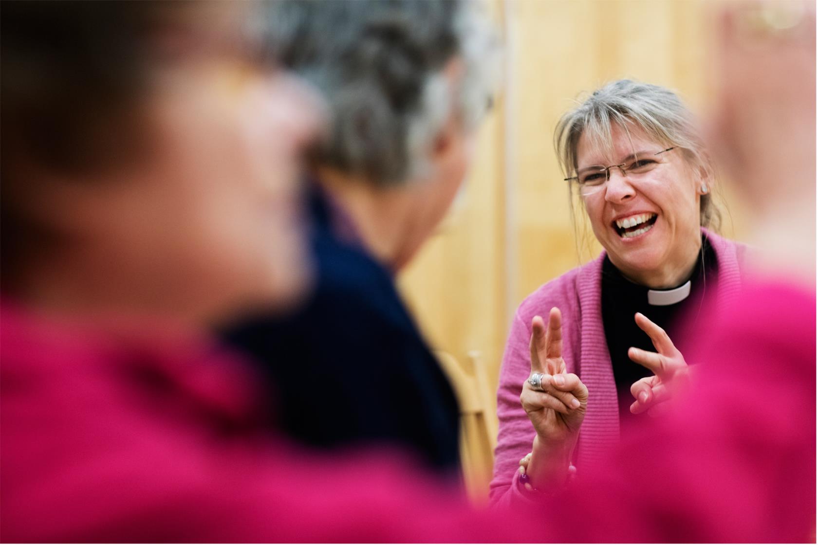 Glad präst i en grupp med vuxna