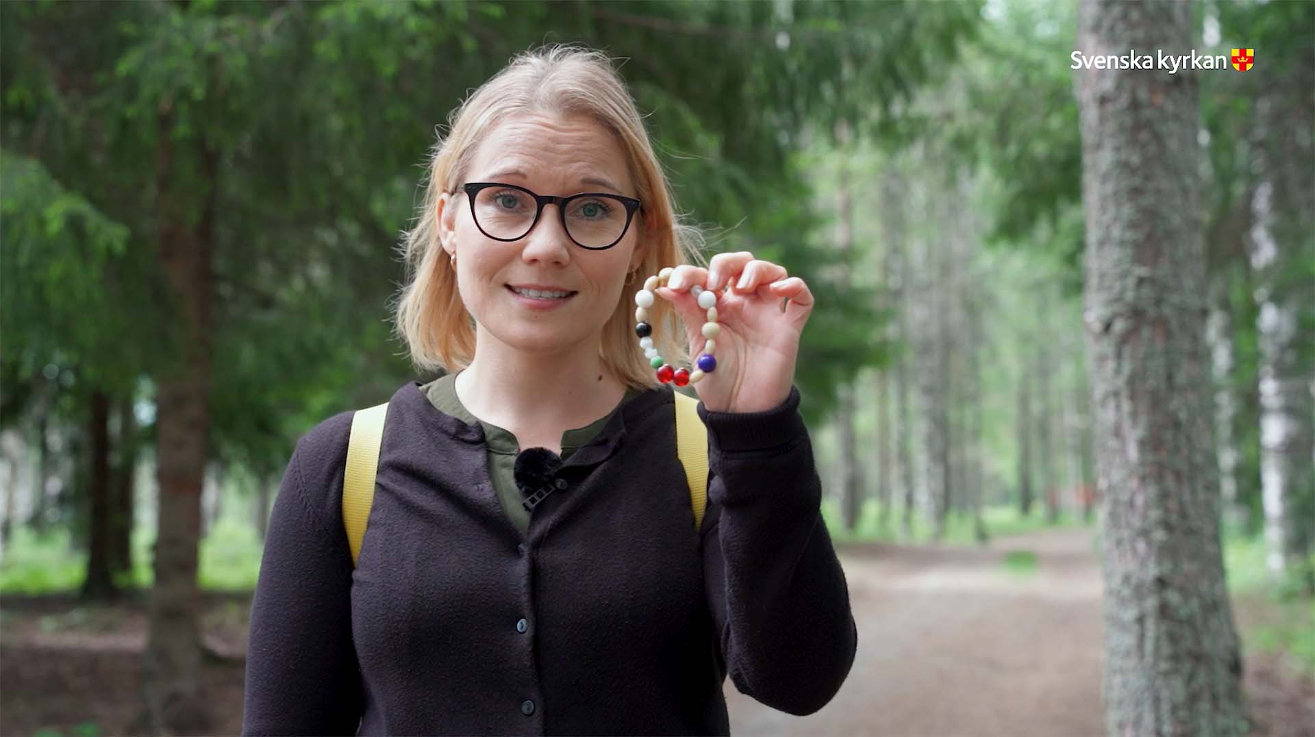 Therese Hamrén håller fram armbandet frälsarkransen.