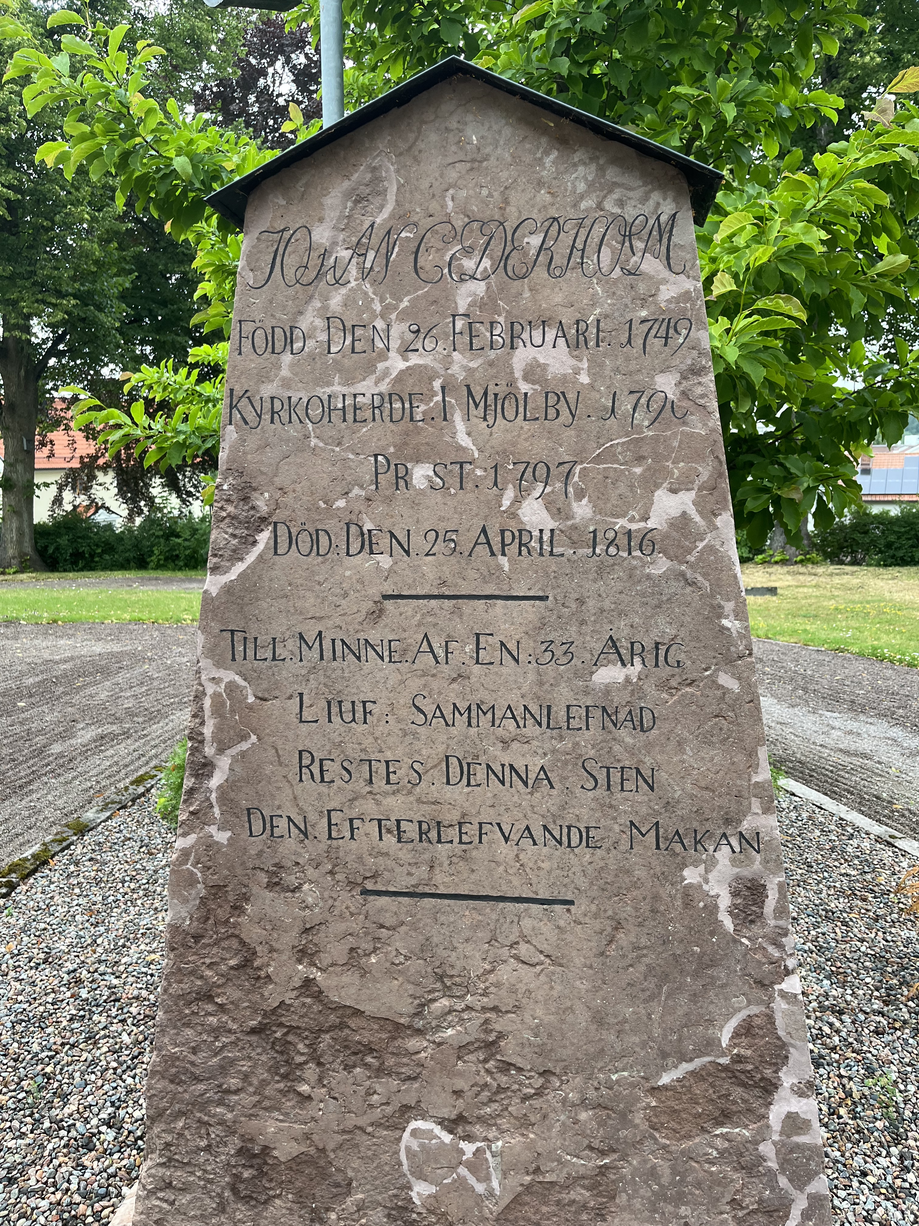Gravsten, en hög sten på Mjölby gamla kyrkogård.