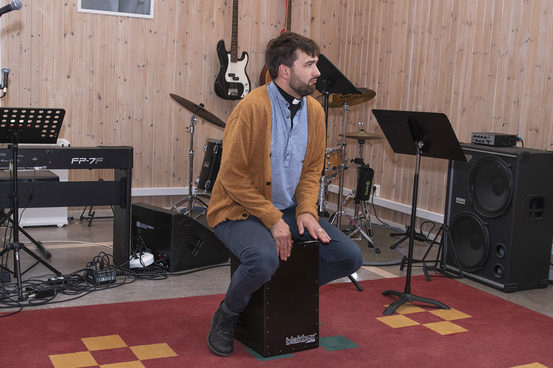 Joel spelar cajón. Cajón är ett peruanskt slagverksinstrument i form av en låda. Man spelar med händerna på framsidan av cajónen, medan man sitter ovanpå lådan. 