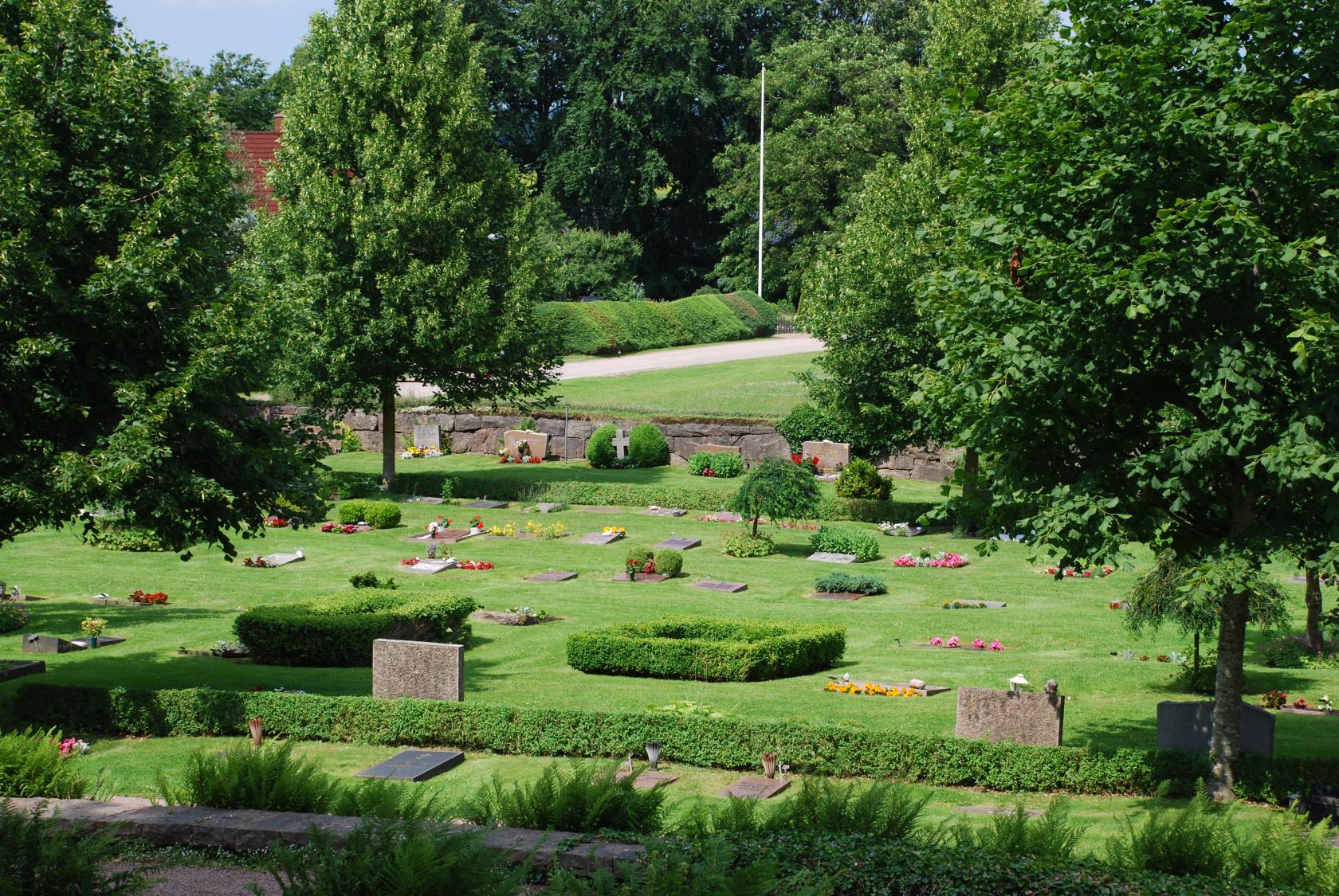 Söndrums kyrkogård med träd i framkant.