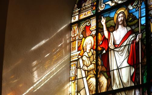Ljusinsläpp från kyrkfönster med Jesus