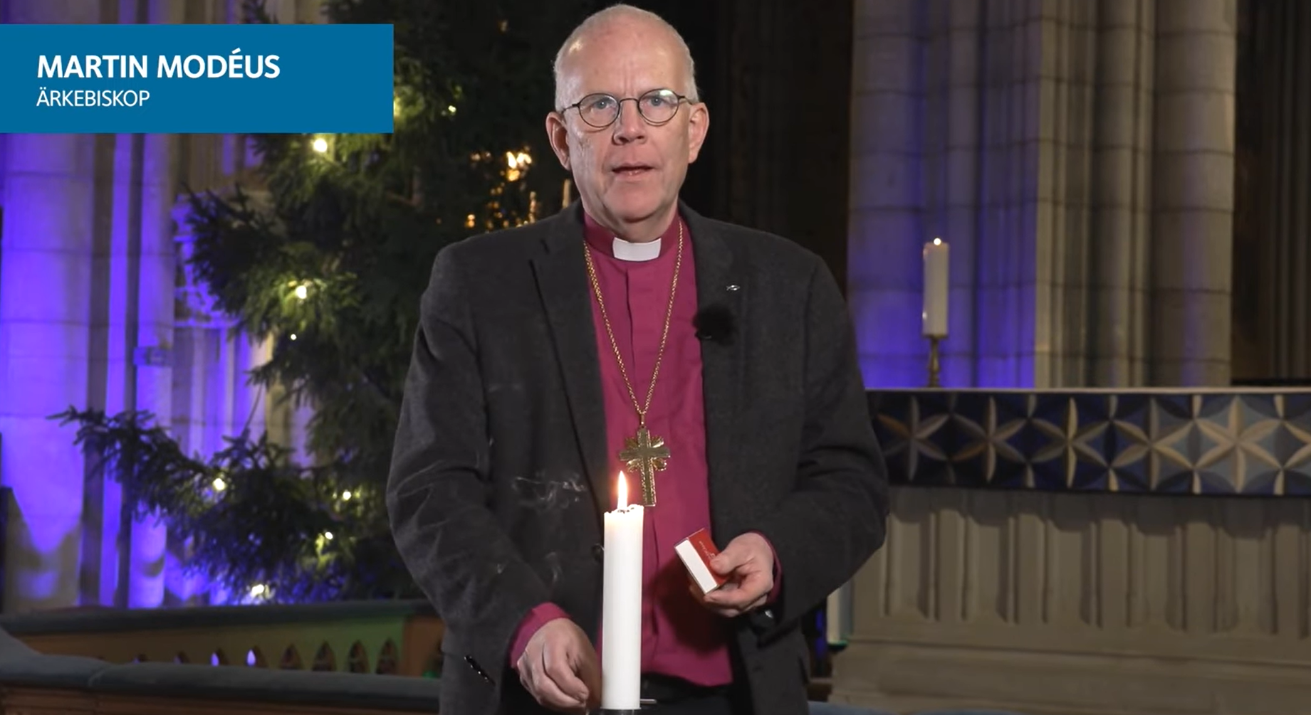 Martin Modéus tänder ett ljus framför kameran i Uppsala domkyrka.