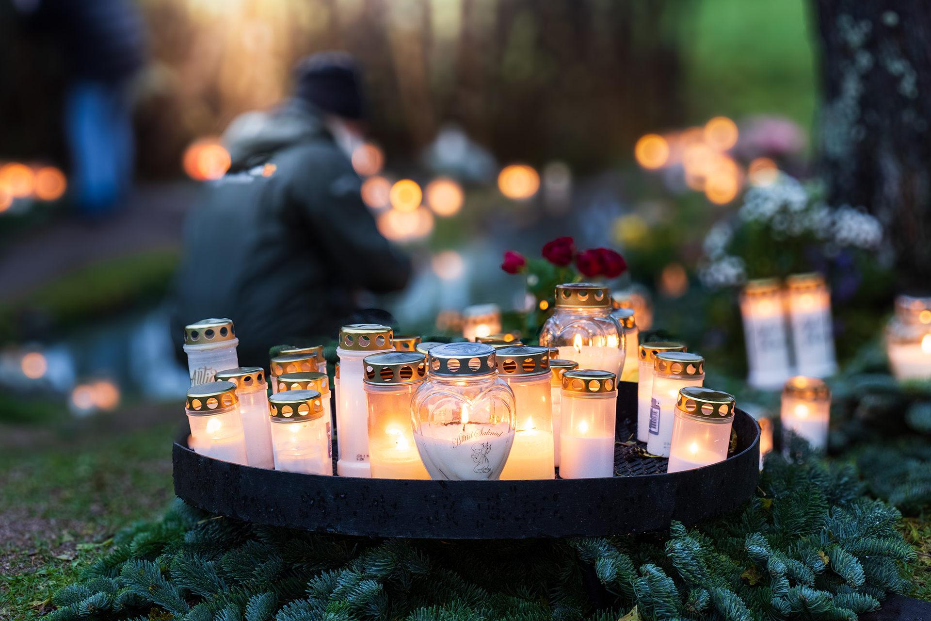 Ljus som glimmar vid Berthåga kyrkogårds minneslund.