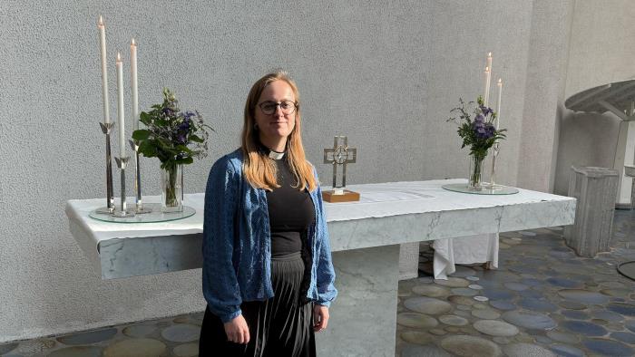 Präst Emma Jansson framför altaret i S:t Matteus kyrka