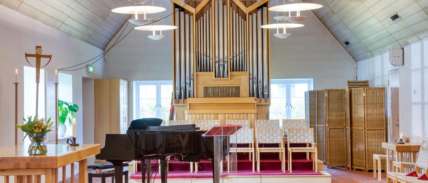 interiör från kyrkorum med flygel orgel i bakgrunden