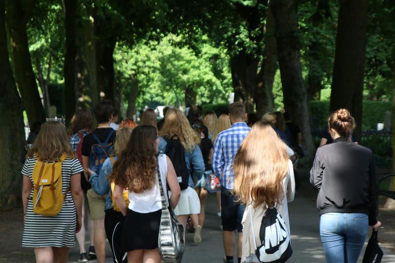 Grupp ungdomar gående i allé