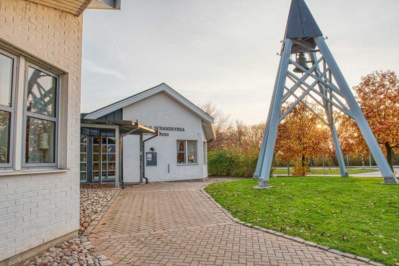 Fristående klockstapel med kyrkklocka utanför Bunkeflo Strandkyrka