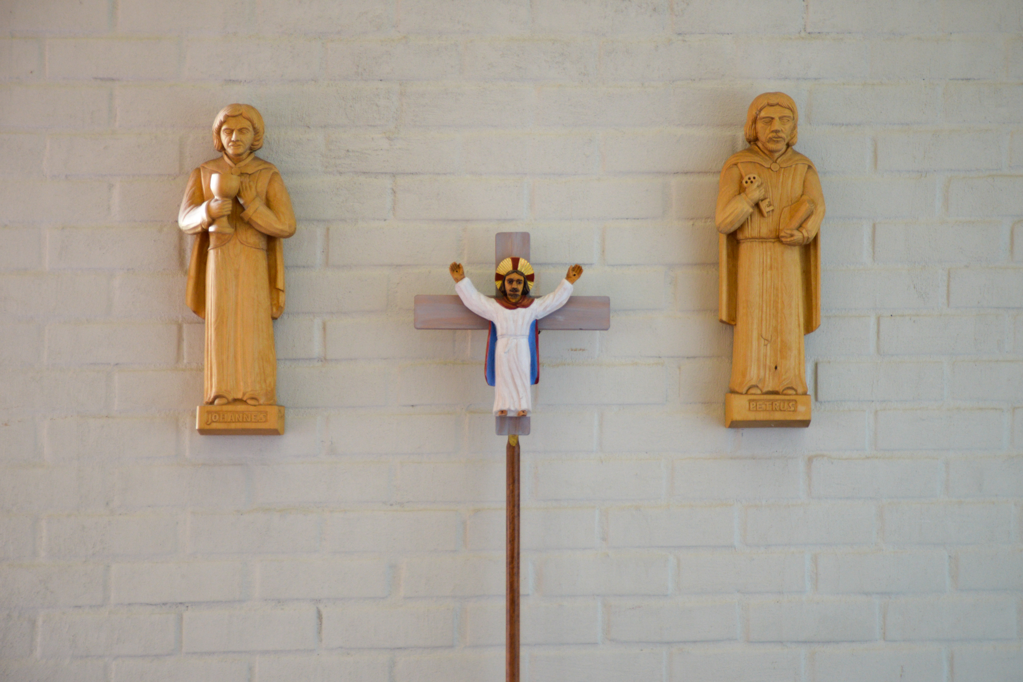 Apostlarna Johannes, med bägare, Petrus, med nyckel och processionskorset är snidade av Emil Sandberg