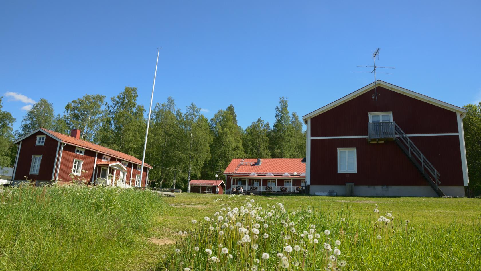 Husen på Kyrkans lägergård med Husmorsvillan till vänster, huvudbyggnaden i mitten och logementet till höger