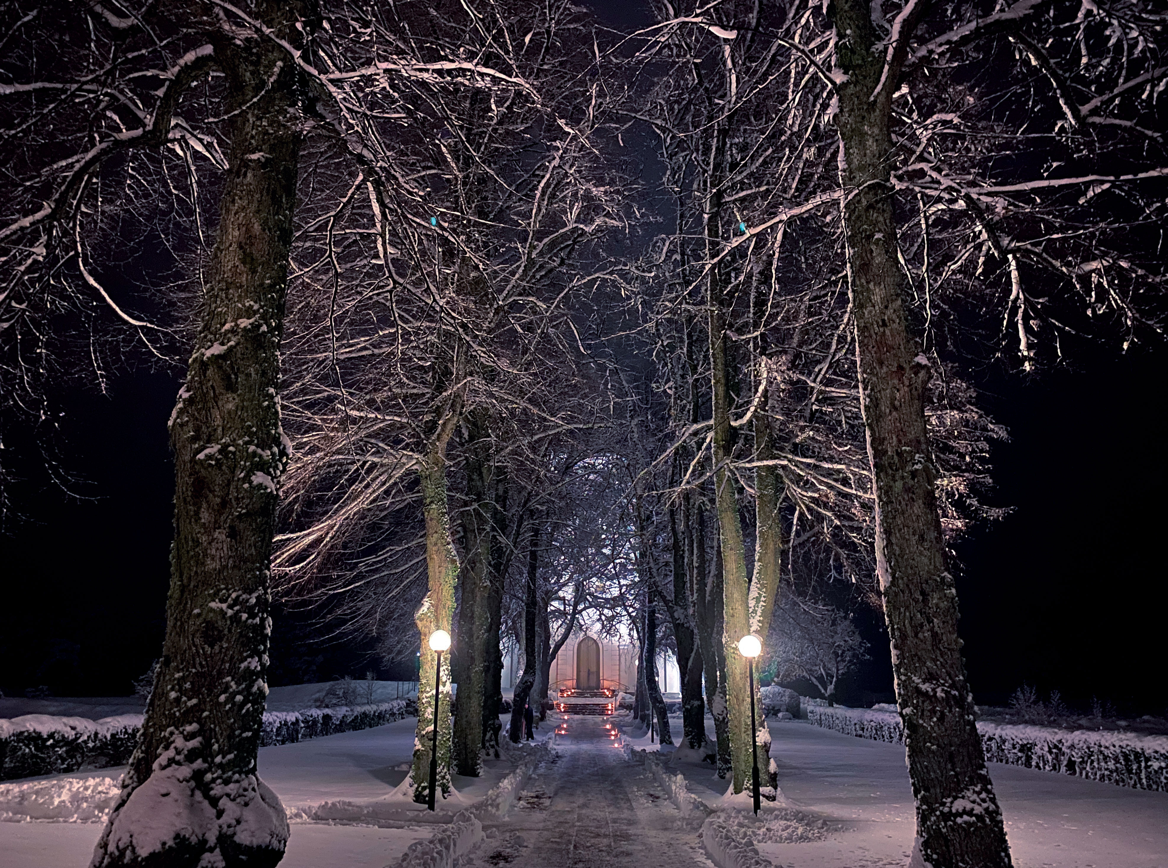 Otterstads kyrka en snöig kväll. Vy längs gången mot porten.