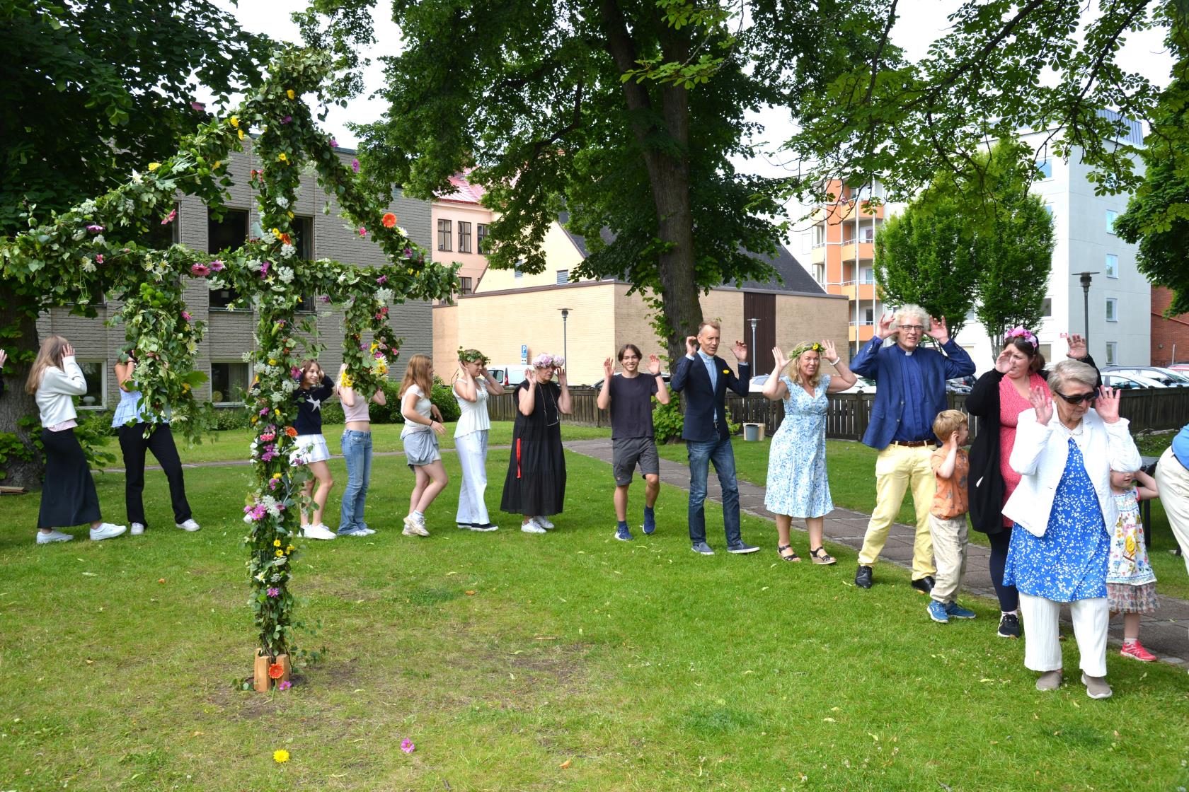 människor dansar runt midsommarstången