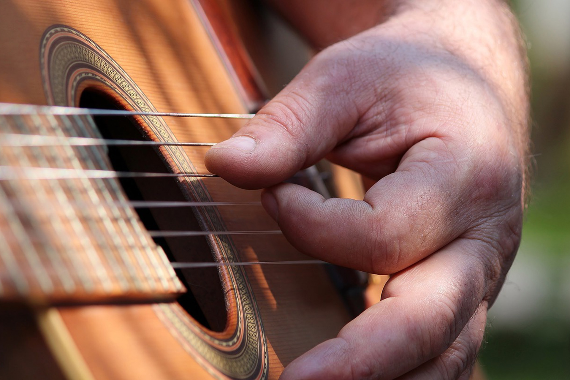 En hand spelar på gitarr.