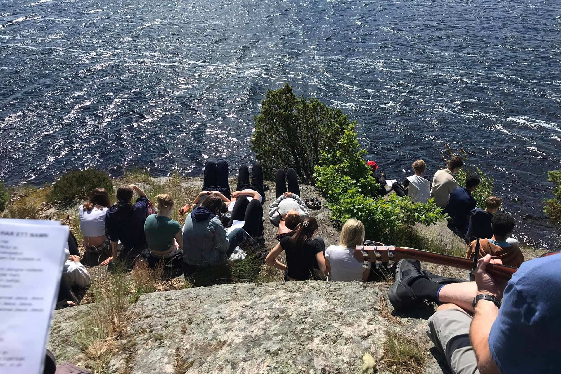 Ungdomar på en klippa på ett läger. 