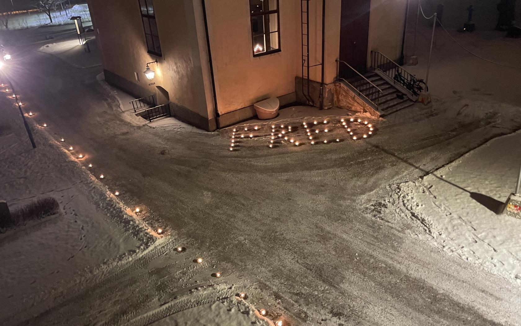 Marschaller som bilder ordet FRED utanför Valbo kyrka.