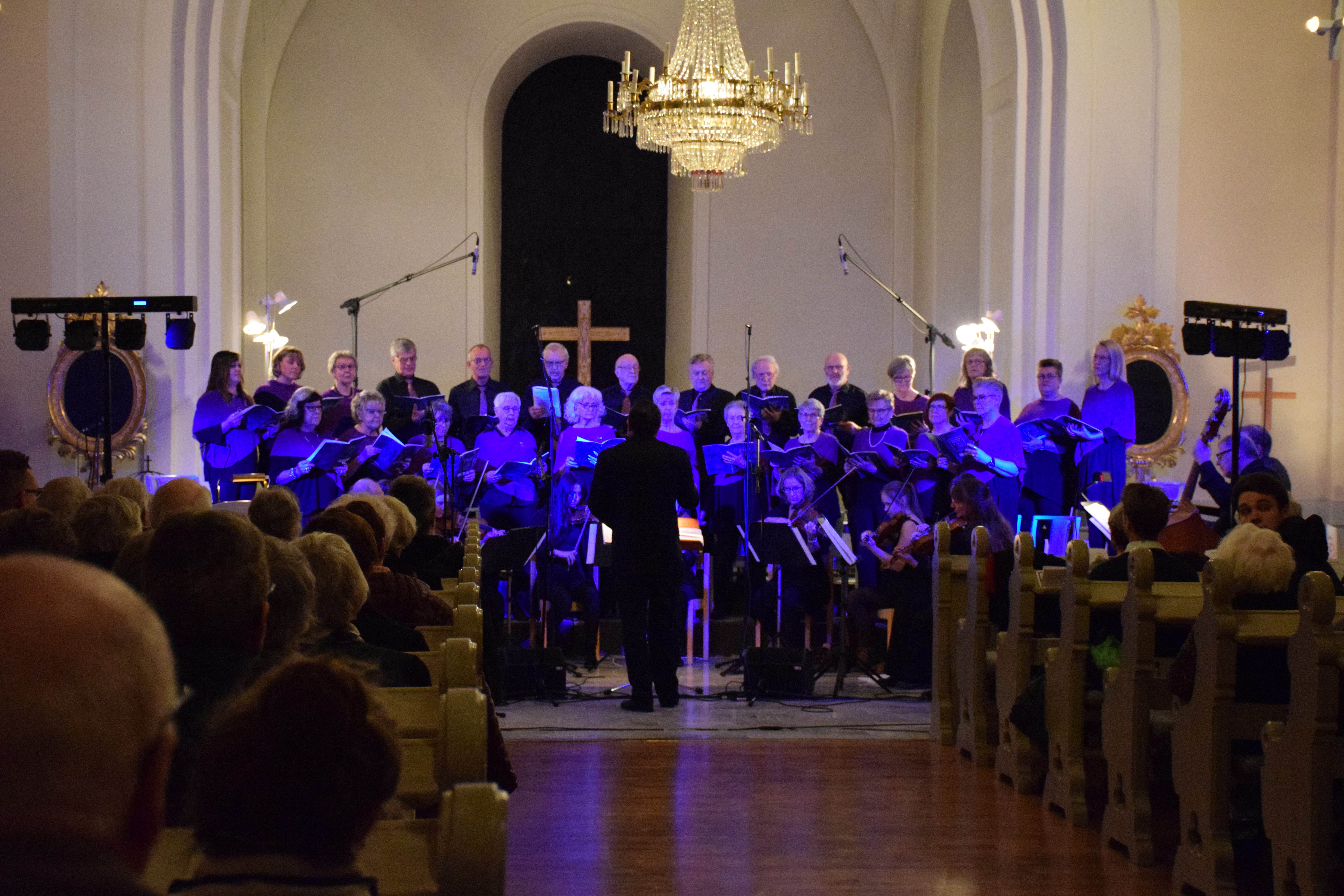 Ytterlännäs kyrkokör sjunger framme i koret inför fullsatt kyrka