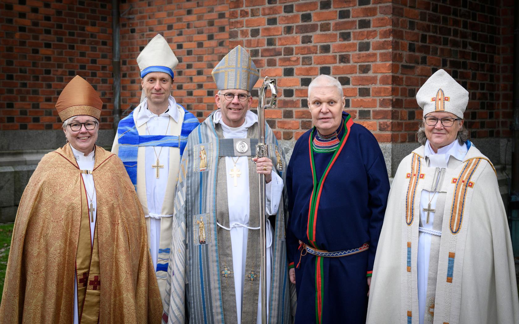 En grupp biskopar står runt ärkebiskop Martin Modéus utanför Uppsala domkyrka.