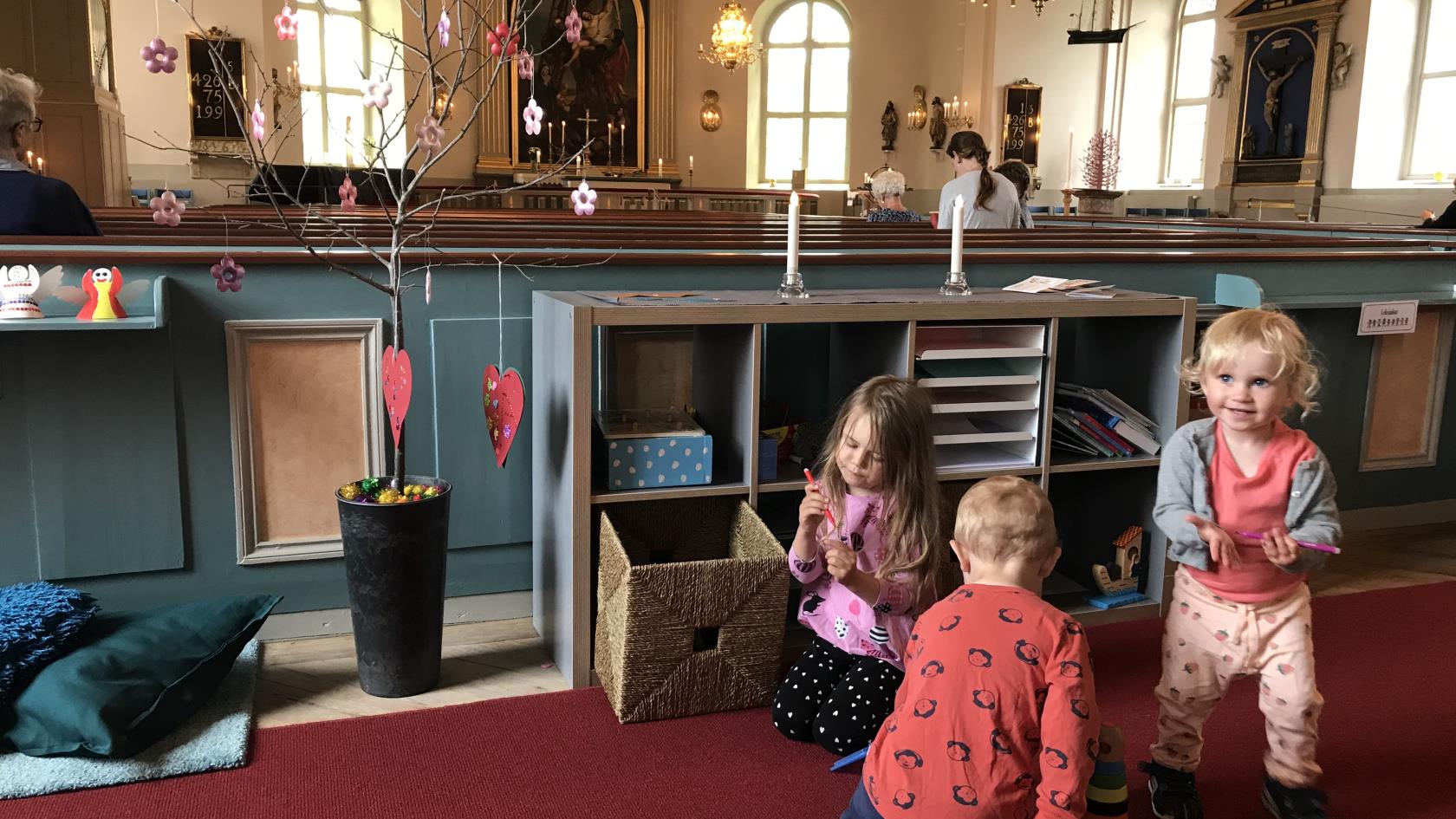 Ellen, Lilly och Sakarias leker i barnhörnan i Mönsterås kyrka. Barnhörnan är placerad i mitten av kyrkan. Placeringen möjliggör för barn och föräldrar att aktivt delta i gudstjänsten och samtidigt hålla fingrarna sysselsatta.