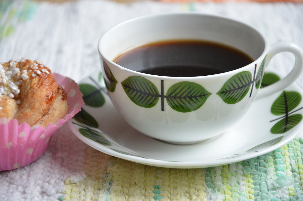 En kaffekopp och en bulle står framdukat på ett bord.