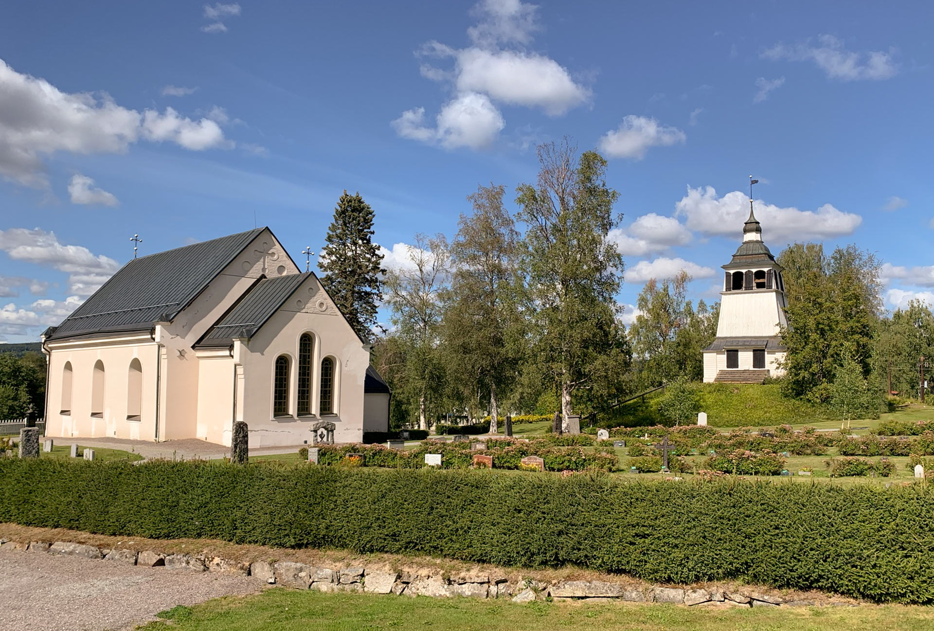 Vybild över kyrka, kyrkogård och klocktorn.