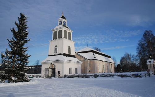 Sollefteå kyrka. En vinterbild. Till vänster står en stor gran.