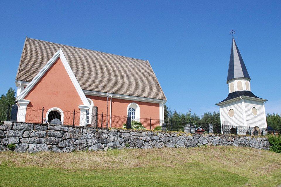 Sånga kyrka och klocktorn. Kyrkan har rödbrun puts. Klocktornet är av trä och vitmålad.