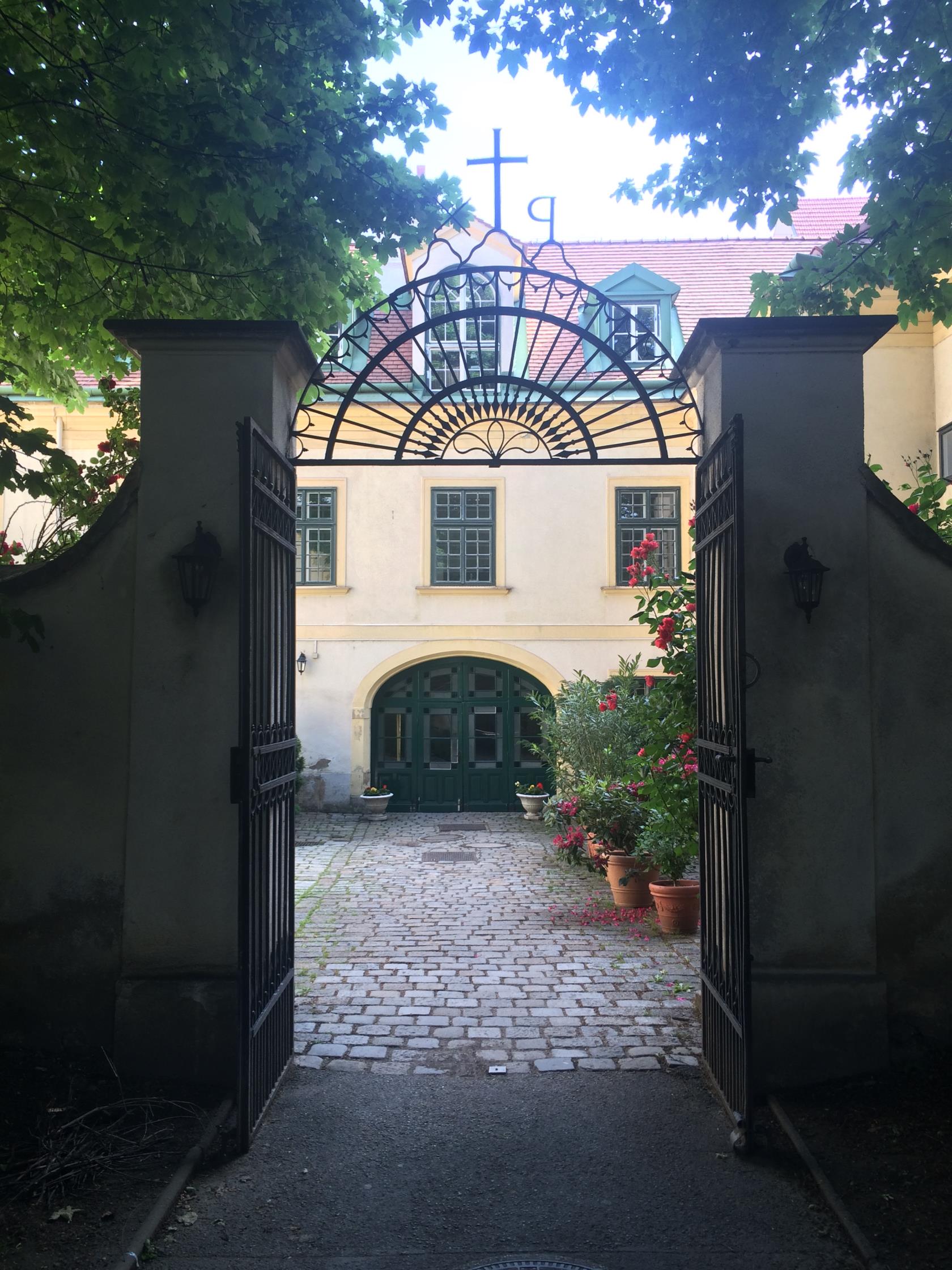 Bild taget mot innergården, kyrkan till höger bakom blomprakten.