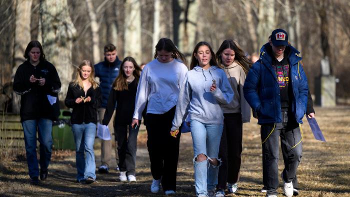 En grupp med ungdomar som promenerar ute i skogen