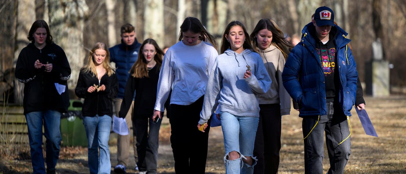 En grupp med ungdomar som promenerar ute i skogen