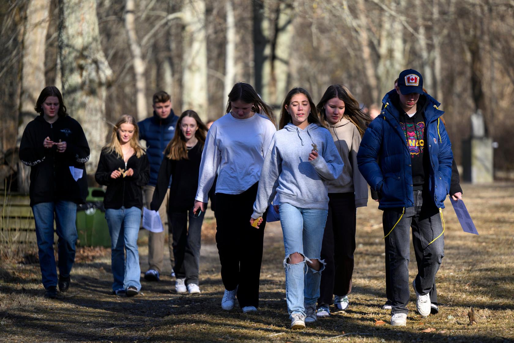 En grupp med ungdomar som promenerar ute i skogen