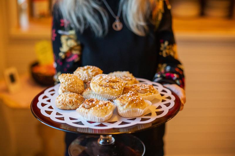 Händer som håller i ett fat med kanelbullar